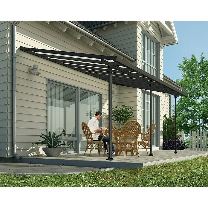 Solid Elements Marquesina adosada Feria - An x Pr: 546 x 300 cm, Gris antracita, Policarbonato, Transparente - Elegante cubierta de patio con un hombre sentado a la mesa. Perfecto para días soleados y horas de relax al aire libre.
