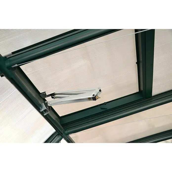 Rion Apertura automática de ventana - Específico para: Ventanas de invernaderos Palram - Primer plano de un abridor de ventanas automático en un invernadero, que garantiza una ventilación óptima. La construcción es robusta y duradera.