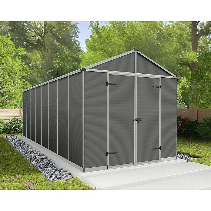 Palram – Canopia Caseta de jardín Rubicon - Medidas ext. (An x Pr): 2,37 x 6,02 m, Plástico, Gris - Vista de un cobertizo de metal gris con puertas dobles y techo a dos aguas en el jardín. Perfecto para guardar herramientas y equipos de jardinería.
