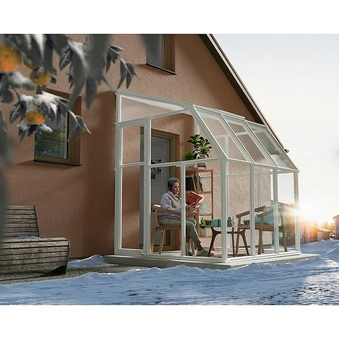 Palram – Canopia Terraza Solarium Sun Room - Medidas ext. (An x Pr): 200 x 200 cm, Plástico, Blanco - Mujer leyendo en un anexo acogedor. El luminoso solárium ofrece un espacio perfecto para relajarse en invierno.