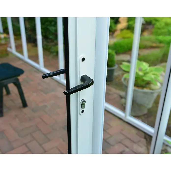 Palram – Canopia Terraza Solarium Sun Room - Medidas ext. (An x Pr): 632 x 257 cm, Plástico, Blanco - Primer plano de un marco de puerta blanco con manija y cerradura negras, que ofrece una vista a un jardín.