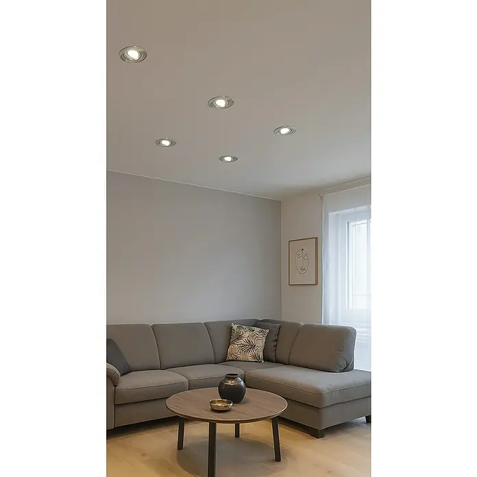 Tween Light Set de focos empotrables - 100 W, Ø x Al: 9,6 x 7 cm, Níquel, 5 ud. - Las luces de techo iluminan la sala de estar con un sofá gris, mesa de madera y decoración minimalista. Los focos empotrados proporcionan un ambiente agradable.