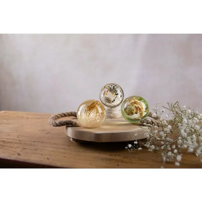 Glorex Bastel-Set Giessharz Kugel - 10 -tlg. - Drei Harzkugeln mit maritimen Elementen und Blattgold auf einem Holztablett mit Seilgriffen und Schleierkraut.
