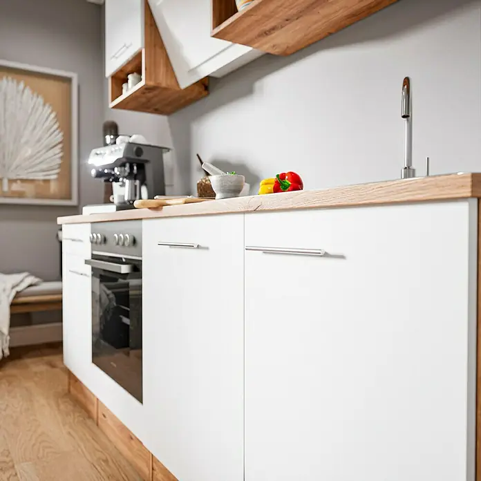 Respekta Cocina compacta Hilde - Ancho: 220 cm, Blanco, Se pueden montar de forma intercambiable, Con electrodomésticos - Armarios bajos de cocina con frentes y tiradores blancos, una encimera de madera, un horno empotrado y una cafetera en la encimera.