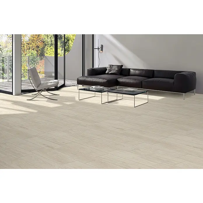 Steingutfliese Legno Natural Avorio - 60 x 15 cm, Beige, Matt - Helle Holzbodenfliesen erhellen ein modernes Wohnzimmer mit schwarzen Ledermöbeln und großen Fenstern, die eine einladende Atmosphäre schaffen.