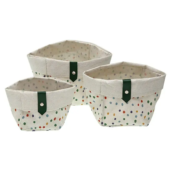 Versa Juego de cestas - Dotty, Poliéster - La imagen muestra un conjunto de tres cestas de almacenamiento de tela con lunares de colores y ribete beige claro, acentuadas con detalles verde oscuro.
