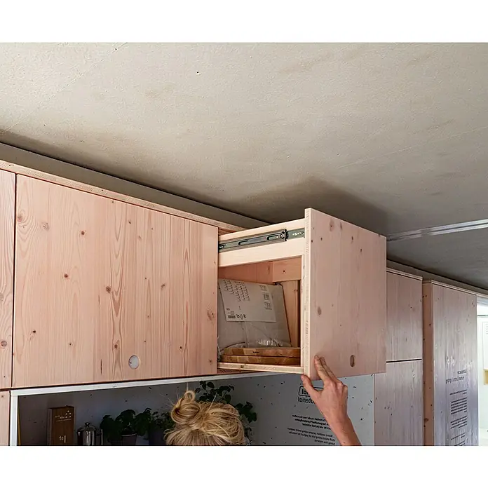 elka 3-Schichtplatte Vita - Douglasie, 2.500 x 660 x 19 mm - Holzschrank mit Schublade, die geöffnet ist und Einblick auf den Inhalt bietet. Die Holzstruktur verleiht dem Möbelstück einen natürlichen Look.