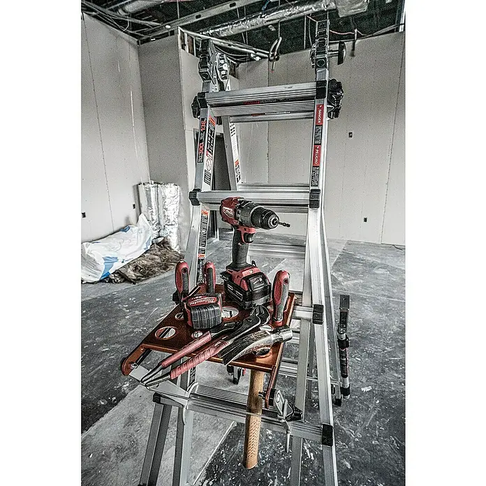 Little Giant Trittablage Platform Pro® - Belastbarkeit: 150 kg - Bild eines verstellbaren Leitersystems mit einer Ablagefläche mit verschiedenen Werkzeugen, darunter Schraubendreher und Zangen.