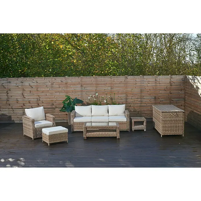 Taburete reposapiés Gotland - L x An x Al: 61 x 51 x 40 cm, Arena - Un elegante juego de patio de ratán con cojines de color crema y una caja de almacenamiento a juego, perfecto para relajarse al aire libre.