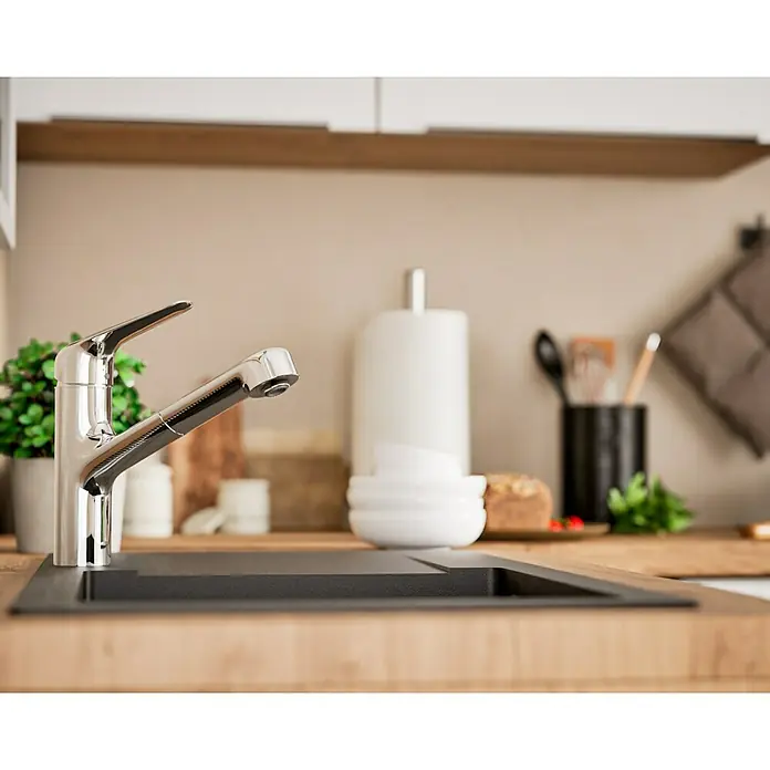 Hansgrohe Focus M41 Grifo de cocina - Cromo, Brillante - Primer plano de un moderno grifo cromado en una encimera de cocina con un fregadero y diversos utensilios de cocina al fondo.
