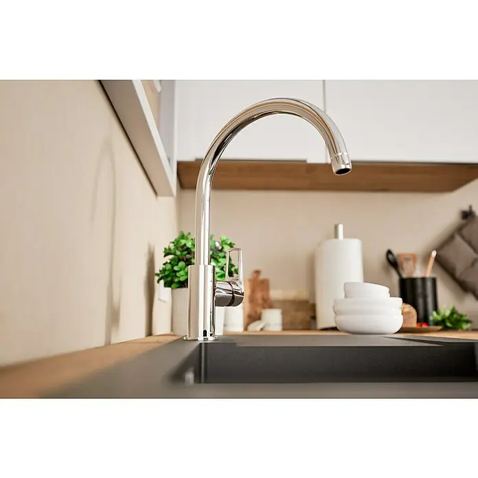Grohe Start Loop Spültischarmatur - Chrom, Glänzend - Nahaufnahme einer glänzenden Küchenarmatur aus Chrom über einem schwarzen Spülbecken, die modernes Design und Funktionalität vereint.