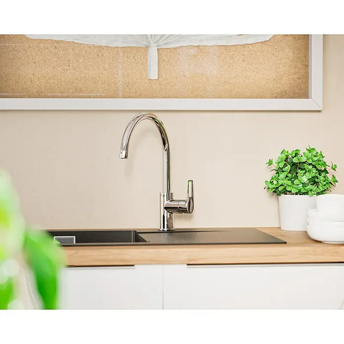 Grohe Start Loop Spültischarmatur - Chrom, Glänzend - Nahaufnahme einer glänzenden Küchenarmatur auf einer Arbeitsplatte mit Spüle, Pflanze und Schüsseln.