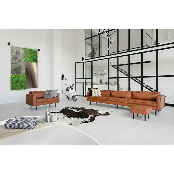 Jangal Wandpaneel Modular Wall Stone - Patina Slate, 1.040 x 520 x 6 mm - Helles Wohnzimmer mit braunem Ledersofa, Sessel, Fellteppich und einer stilvollen Raumaufteilung durch Glaswände. Die Möblierung wirkt einladend.