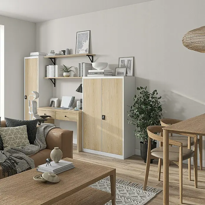 Jan Nowak Aktenschrank Kevin - B x T x H: 90 x 40 x 140 cm, Weiß/Sonoma eiche - Ein gemütliches Wohnzimmer mit einem hellen Holzschrank, einem Schreibtisch und einem Ledersofa, das eine warme und einladende Atmosphäre schafft.