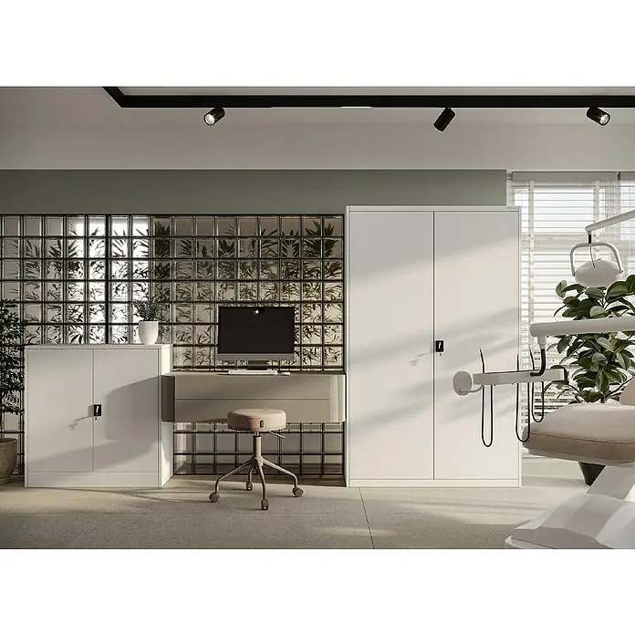 Jan Nowak Aktenschrank Kevin - B x T x H: 90 x 40 x 140 cm, Grau - Helle Zahnarztpraxis mit weißem Schrank, Schreibtisch und Stuhl vor einer Glasbausteinwand. Moderne Beleuchtung sorgt für ein angenehmes Ambiente.