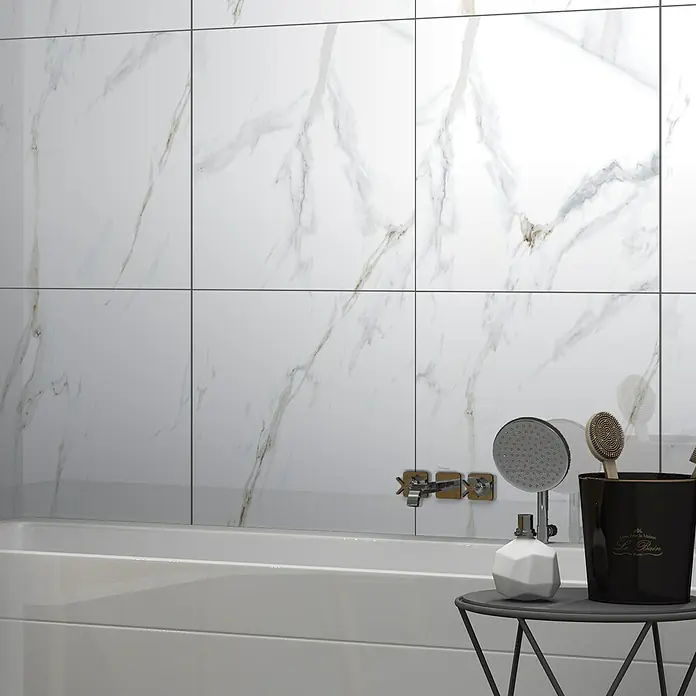 Feinsteinzeugfliese Calacatta - 60 x 60 cm, Weiß/Gold, Glänzend - Nahaufnahme eines modernen Badezimmers mit Marmorfliesen, einer weißen Badewanne und stilvollen Accessoires auf einem kleinen Tisch.