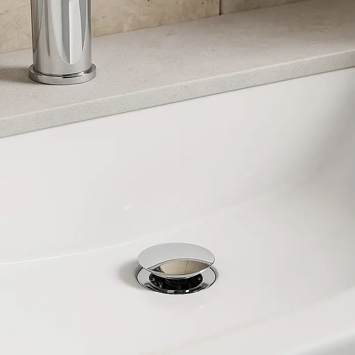 Imex Válvula click clack - 1¼'', Latón, Cromo - Primer plano de un lavabo con un elegante desagüe emergente cromado, que combina funcionalidad con diseño moderno.