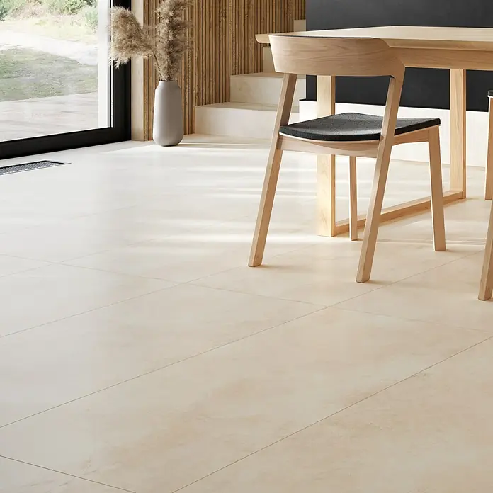 Queens Feinsteinzeugfliese - 29,8 x 59,8 cm, Beige, Matt - Ansicht von hellen, rechteckigen Bodenfliesen im Innenraum mit Tisch und Stuhl. Perfekt für moderne Wohnräume.
