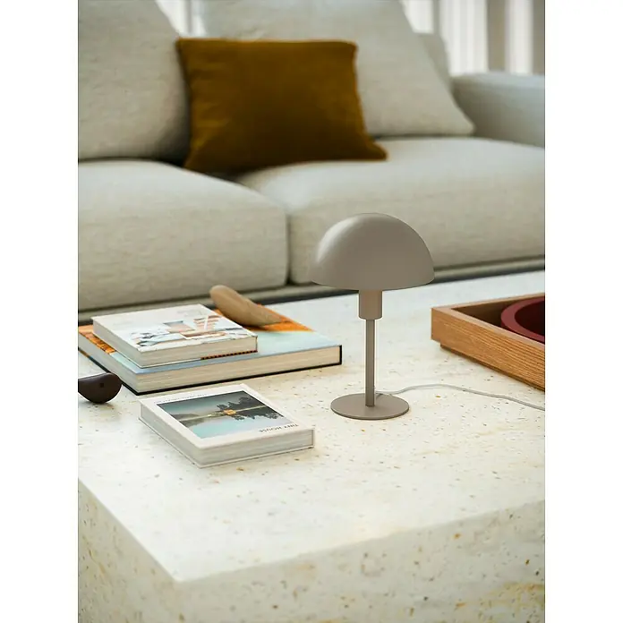 Nordlux Lámpara de sobremesa Ellen mini - 40 W, L x An x Al: 16 x 16 x 25 cm, Marrón, E14 - Lámpara de mesa gris minimalista sobre una mesa con libros y decoración, frente a un sofá claro.