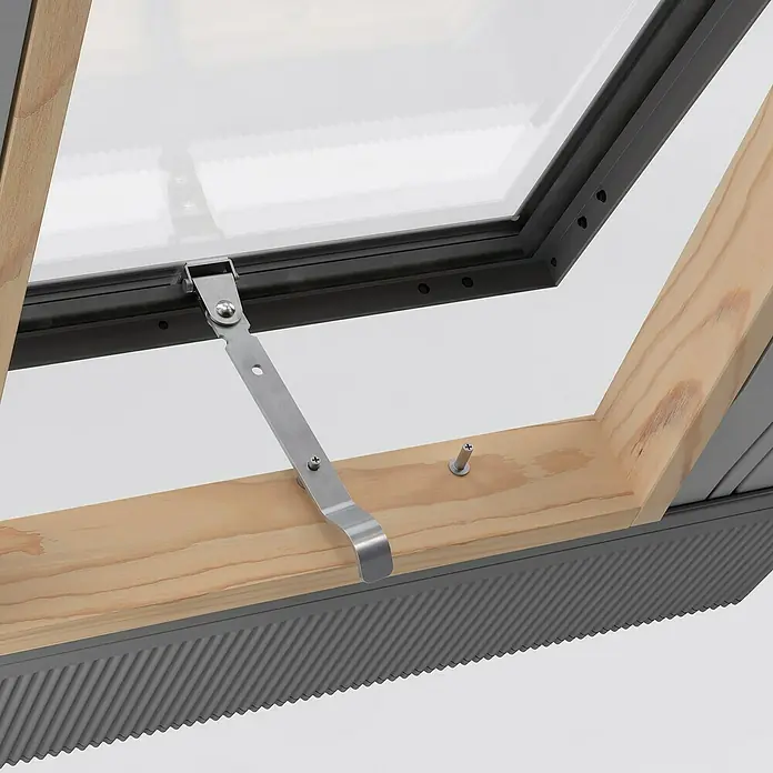Dachausstieg - 65 x 65 cm, Farbton außen: RAL 7043, Mit Öffnungsbegrenzer - Nahaufnahme eines Dachfensters mit silbernem Beschlag an einem hellen Holzrahmen, der an einer grauen, geriffelten Oberfläche befestigt ist.