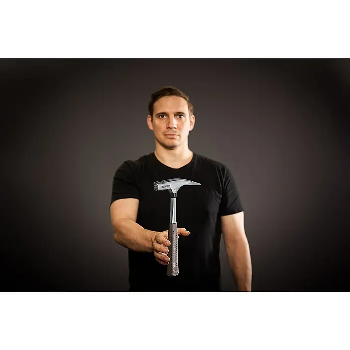 Picard Zimmermannshammer - Gewicht Kopf: 600 g, Braun - Ein Mann hält einen GERKO 200 Zimmereihammer in der Hand. Der Hammer hat einen robusten Griff und einen präzisen Kopf für Zimmermannsarbeiten.