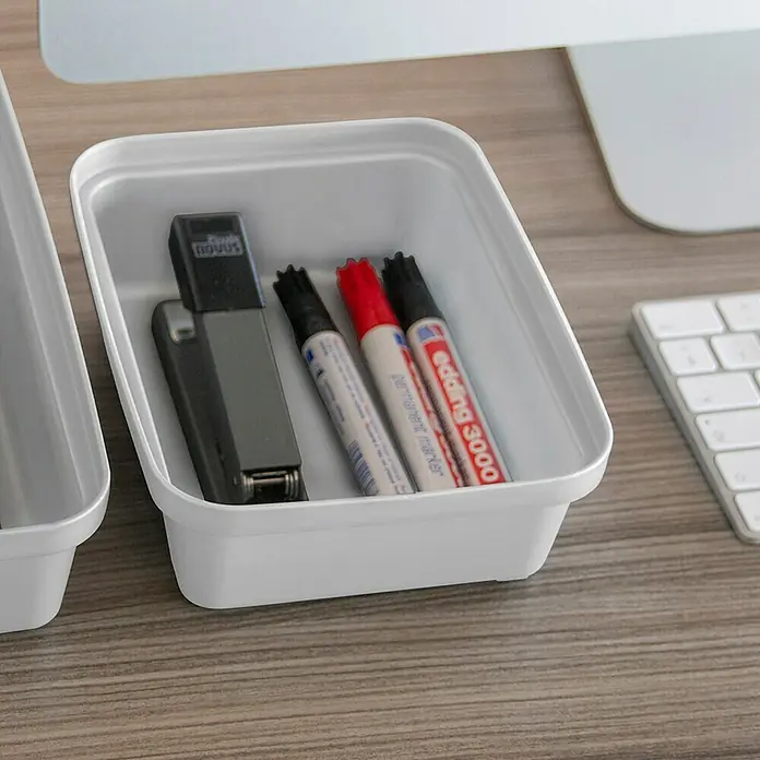 Sunware Sigma home Aufbewahrungsbox Pencil - L x B x H: 18,8 x 14,7 x 6 cm, Kunststoff, Weiß - Ein weißer Organizer mit einem grauen Tacker und drei farbigen Markern auf einem Holztisch neben einer Tastatur und einem Bildschirm.