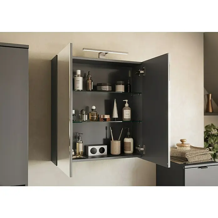 Germania Arcena LED-Spiegelschrank - B x H: 60 x 71 cm, Holz, Graphit - Ein offener Spiegelschrank mit diversen Badartikeln auf Glasböden und einem Handtuchstapel daneben. Das Badmöbelstück ist stilvoll und funktional.