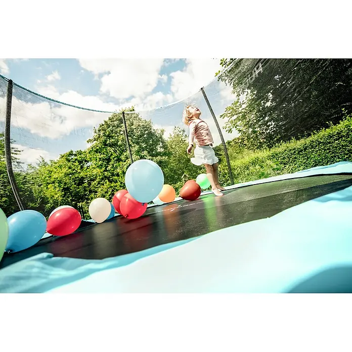 Hudora Trampolin Fantastic Complete 300 V - Durchmesser: 300 cm - Kind springt auf Trampolin mit bunten Ballons im Garten, umgeben von Bäumen und blauem Himmel.