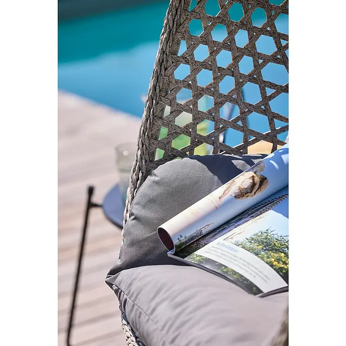 Sunfun Hängesessel - L x B x H: 103 x 95 x 196 cm, Stahl, Grau/Schwarz - Nahaufnahme eines Outdoor-Stuhls mit Kissen und Magazin am Pool, der zum Entspannen und Genießen einlädt.