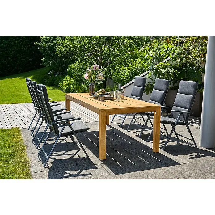 Sunfun Gartenmöbel-Set Laura/Maja - 13 -tlg., Akazie, Aluminium, Textilen, Olefin, Naturbraun/Night-Grey - Ein Teakholztisch mit vier Klappstühlen mit grauen Auflagen steht auf einer Terrasse und lädt zu einem Essen im Freien ein.
