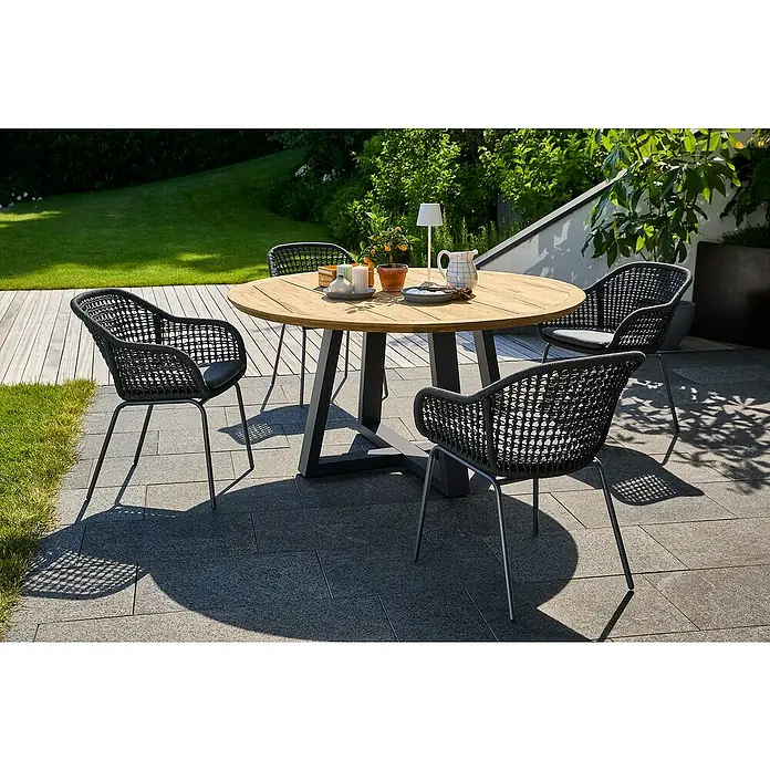 Sunfun Gartenmöbel-Set Sarah Rope - 6 -tlg., Aluminium, Stahl, Teak, Grau, Natur - Ein runder Holztisch mit vier schwarzen Stühlen im Freien. Das Tischset beinhaltet Geschirr und Dekorationen für eine elegante Atmosphäre.