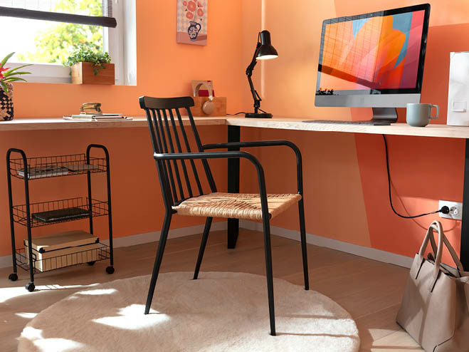 Kleines Home Office mit Stuhl, Beistellwagen und einem Eckschreibtisch, die Wand in der Trendfarbe Peach Fuzz gestrichen