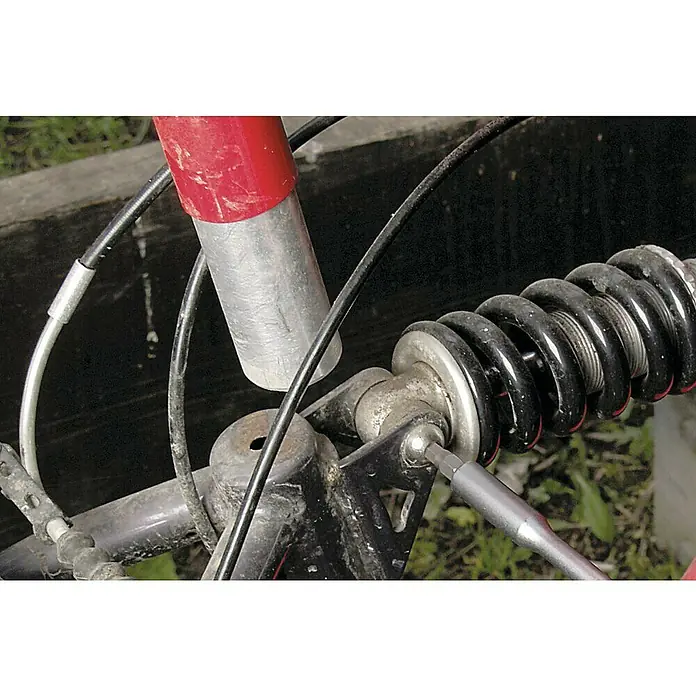 Wolfcraft Set de puntas - 32 pzs. - Primer plano de un amortiguador de bicicleta que está siendo reparado con una llave inglesa plateada. Imagen detallada de la reparación de la bicicleta.