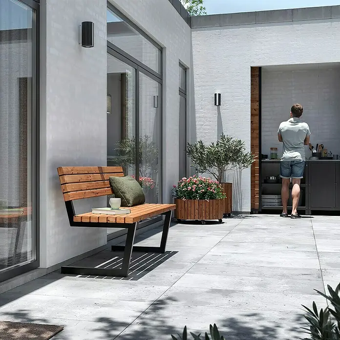 Plus Gartenbank Relax - B x T x H: 150 x 52 x 82 cm, Thermowood, Stahl, Schwarz/Braun, ohne Hängebank - Eine stilvolle Holzbank mit dunklem Metallgestell im Außenbereich, ergänzt durch ein grünes Kissen und eine Tasse.