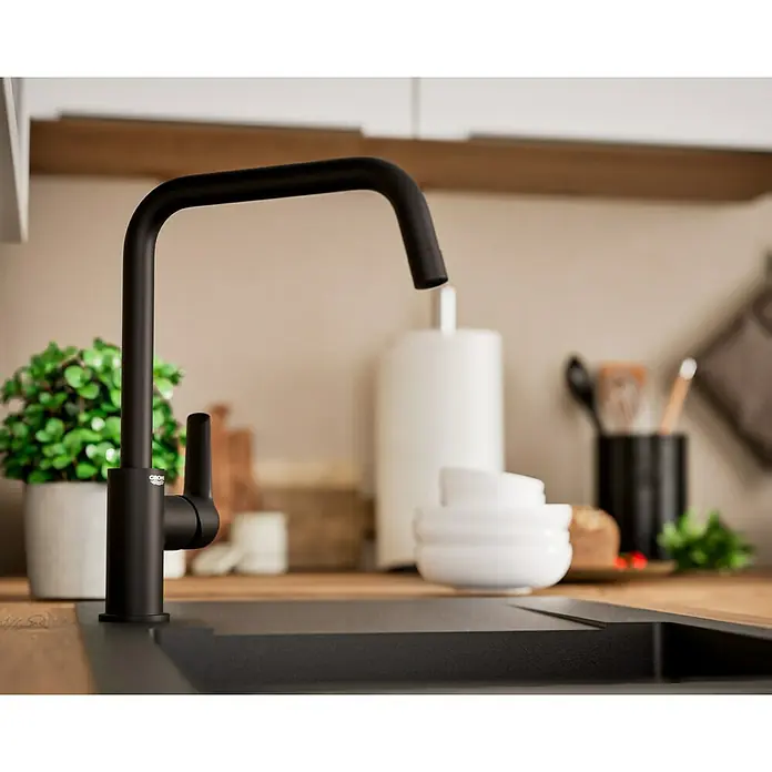 Grohe Start Spültischarmatur - Ausladung Armatur: 228 mm, Schwarz, Matt - Ein moderner, schwarzer Grohe Wasserhahn ziert eine stilvolle Küchentheke. Der minimalistische Wasserhahn ist der Fokus des Bildes.
