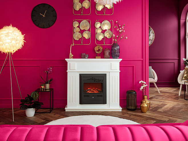 Die Wände sind in Magenta gestrichen, in der Mitte vom Wohnraum ein weißer, elektrischer Kamin 