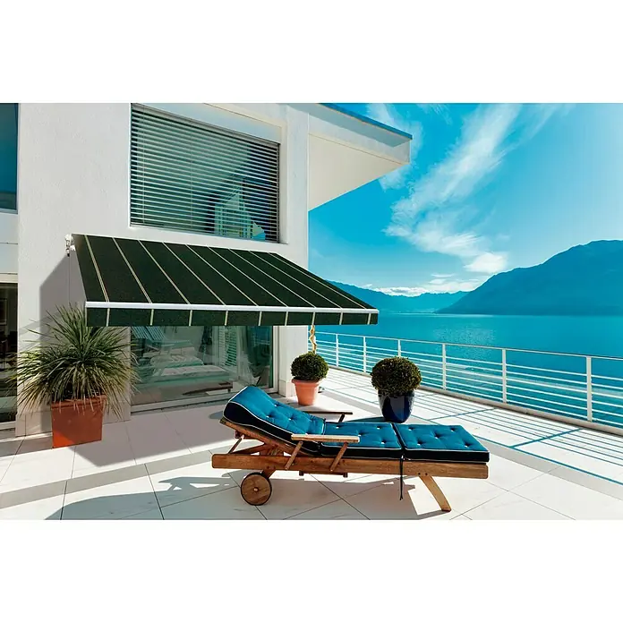 SmartSun Toldo de brazos extensibles Original Kit Acrílico - Gris oscuro, Ancho: 3 m, Caída: 2 m - Exterior de una casa con un toldo verde sobre un patio con una tumbona y vistas al agua.