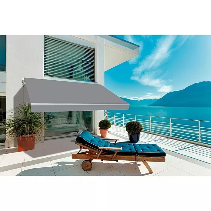 SmartSun Toldo de brazos extensibles Original Kit Acrílico - Gris, Ancho: 3 m, Caída: 2 m - Toldo gris retráctil instalado en el patio de un edificio moderno, cubriendo una tumbona con vista al lago.