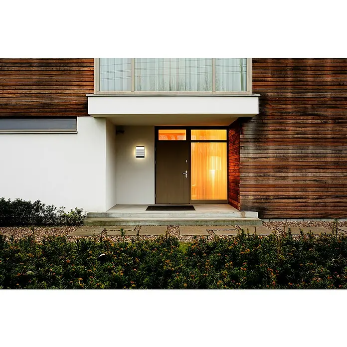 E2 elektro LED-Außenwandleuchte Vega - 7,5 W, 16 x 20 x 6,2 cm, Anthrazit, IP65 - Moderne Hausfassade mit Holzverkleidung, Eingangstür mit Glasseitenteil und integrierter Außenleuchte.