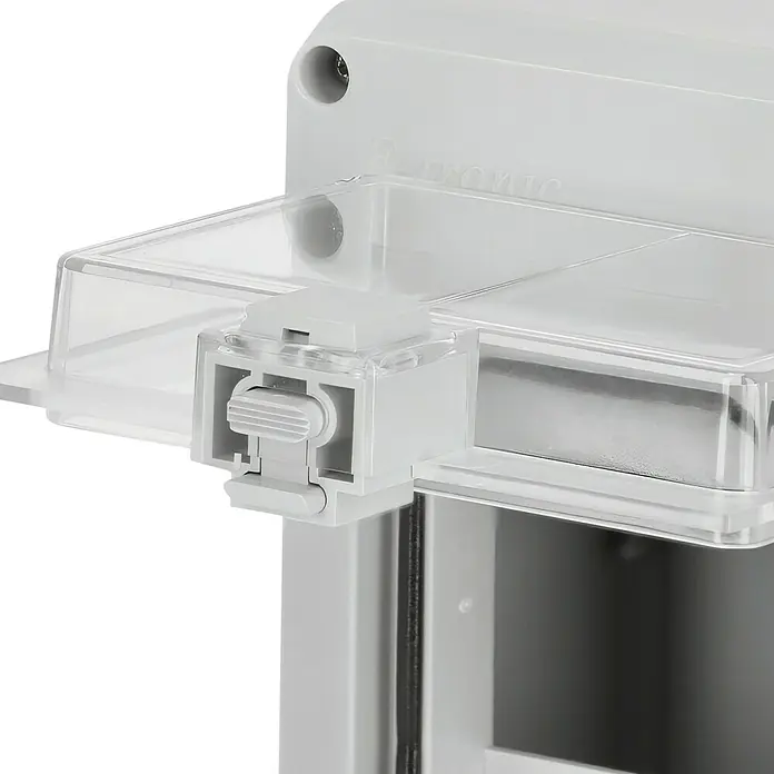 F-tronic Aufputz-Verteiler Feuchtraum - Anzahl Reihen: 1 Stk., 16 x 9 cm, Grau - Nahaufnahme einer transparenten Abdeckung an einer grauen Steuerungseinheit, die Details der Verschlussmechanismen hervorhebt.