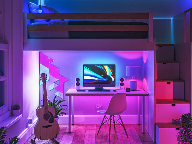 Nische unter dem Stockbett mit Schreibtisch und PC, an der Wand LED-Paneele in pink und türkis