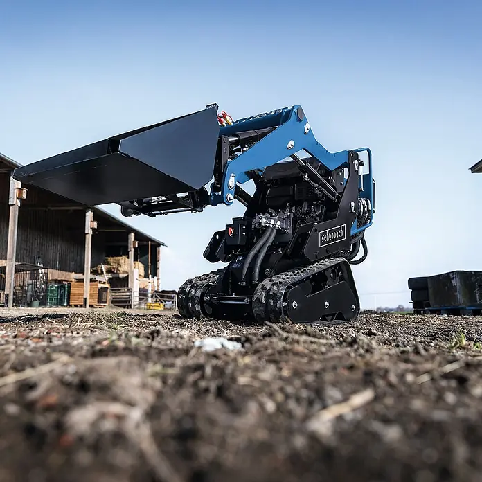 Scheppach Kompaktlader MKL730 - Benzin, Traglast: 200 kg, Tankvolumen: 6 l - Kompakter Scheppach Minilader auf unebenem Gelände mit hochgehobener Schaufel, ideal für Bau- und Gartenarbeiten.