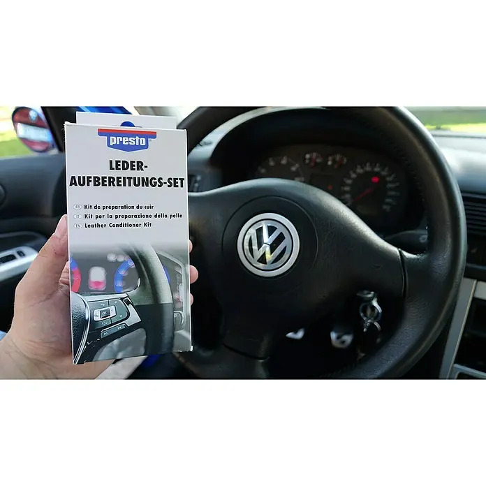 Presto Lederpflege Aufbereitungs-Set - Farblos, 30 ml, 5 -tlg. - Nahaufnahme eines Presto Lederpflege-Sets vor einem Volkswagen-Lenkrad, ideal für die Lederaufbereitung im Auto.