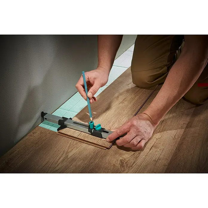 Wolfcraft Anreißlehre - Länge: 295 mm - Ein Mann verwendet das Wolfcraft Laminat Verlegewerkzeug zum Anzeichnen der Laminatbretter für eine passgenaue Installation.
