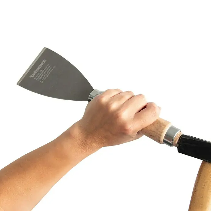 Wisent Stoßspachtel - Klingenbreite: 80 mm - Nahaufnahme einer Hand, die einen Wisent Spachtel mit Holzgriff hält. Das Werkzeug ist scharf und ideal für präzise Arbeiten.