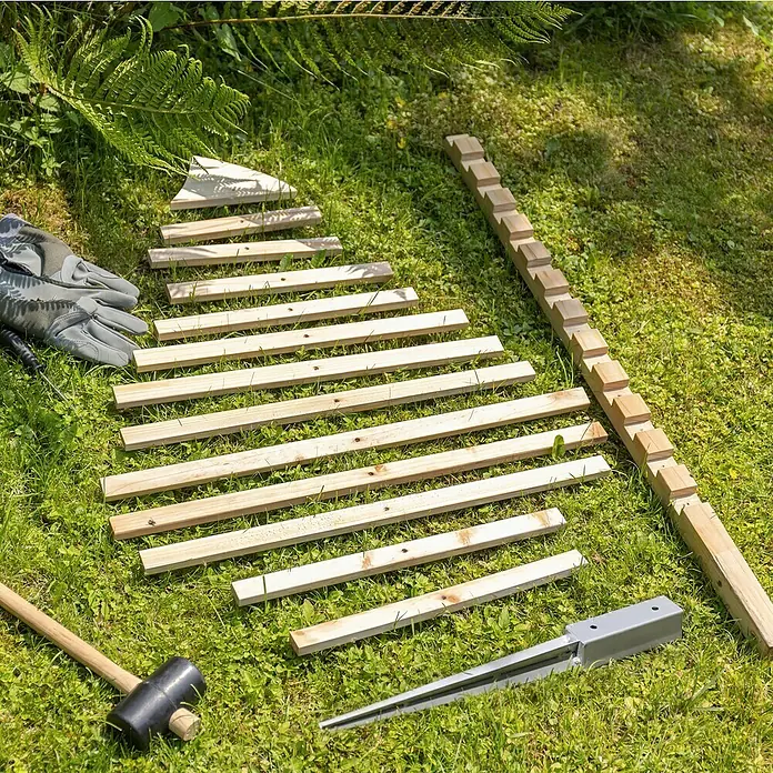 Rankhilfe - B x H: 70 x 119 cm, Holz, Braun - Bausatz für eine DIY Hochbeet-Einfassung aus Holz mit Erdankern, Handschuhen und Gummihammer auf einer grünen Wiese.