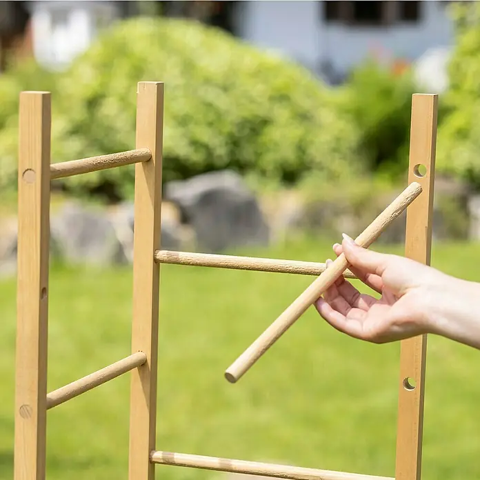 Windhager Rankhilfe Turm - L x B x H: 29 x 29 x 145 cm, Holz - Eine Hand setzt einen Holzstab in ein Holzgestell im Freien ein. Ideal zur Gartendeko oder als Rankhilfe für Pflanzen.