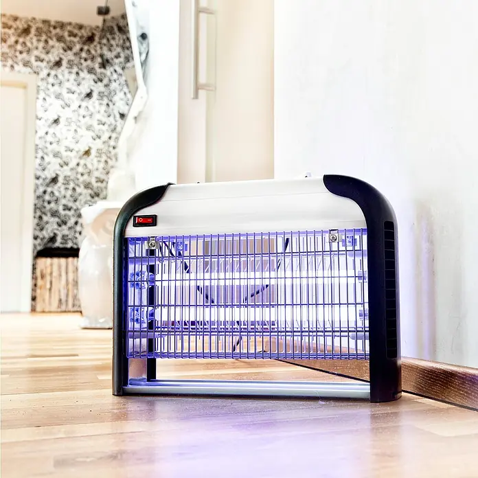 Windhager UV-Mückenlampe Comfortable+ - 40 W, Wirkungsbereich: 100 m² - Ein Insektenvernichter mit blauem Licht steht auf einem Holzboden. Der Insektenfänger hat ein weißes Gehäuse und schwarze Endkappen.