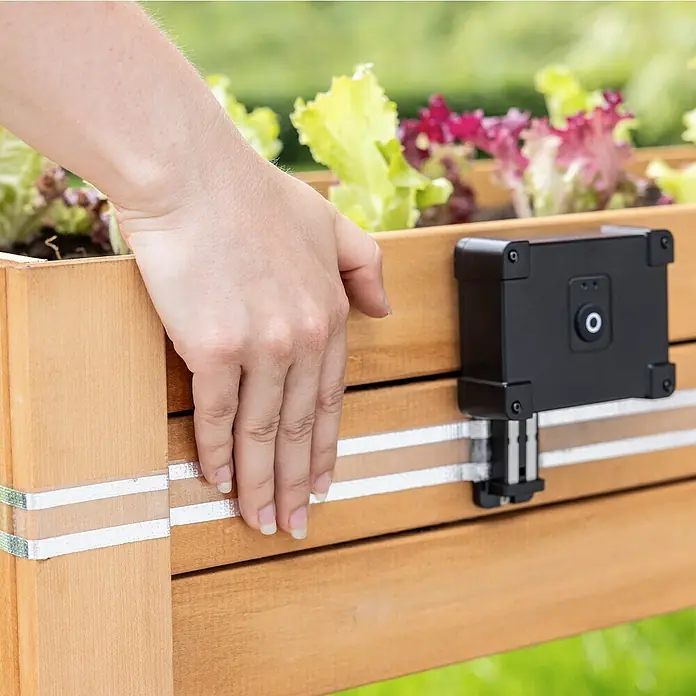 Windhager Schneckenband e-FENCE Tape - 10 m, Passend für: Windhager Schneckenabwehr e-FENCE - Nahaufnahme eines Smart Home-Gartenprodukts, das an einem Holzkasten befestigt ist, mit Salatpflanzen oben.
