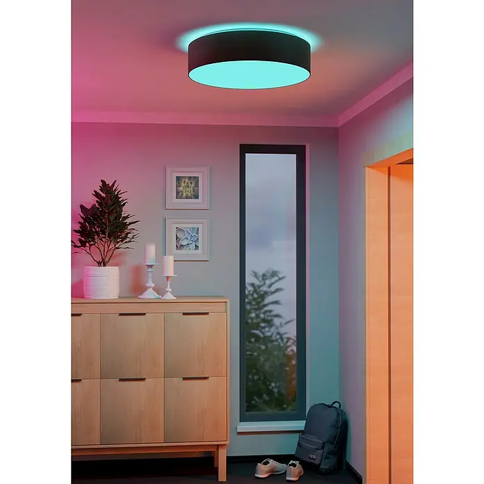 Eglo connect.z LED-Deckenleuchte ROMARO-Z - 35 W, Ø x H: 57 x 15 cm, Dimmbar - Das Bild zeigt eine moderne Deckenleuchte in einem stilvollen Raum, die ein angenehmes, farbiges Licht ausstrahlt.